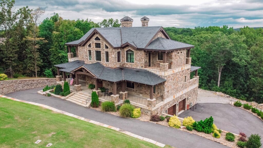 Nashville drone pilot aerial view of luxury stone mansion and landscaped grounds.