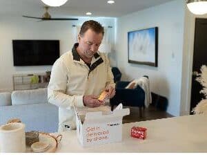A man receiving a drone-delivered package