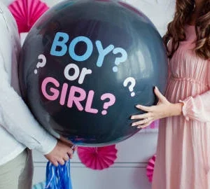 Joyful gender reveal party with colorful decorations and excited guests celebrating the babys gender.
