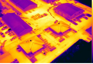 Drones conducting thermal inspections for efficient building health and energy performance assessment.
