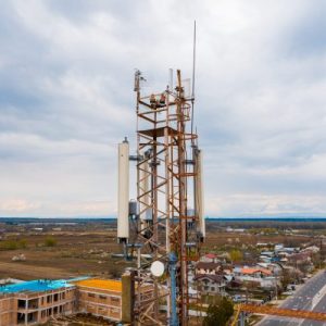 Drone inspecting a telecom tower for maintenance and structural evaluation.