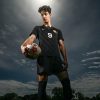 Young Soccer Forward With Ball Under Dramatic Sky