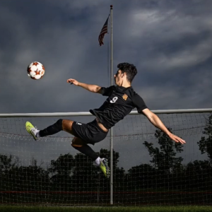 Wisconsin soccer goalkeeper makes dramatic diving save under stormy sky.