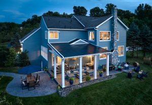 Modern Blue Home Exterior With Patio at Twilight