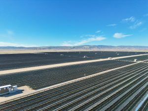 Expansive Solar Farm Under Blue Mountain Sky
