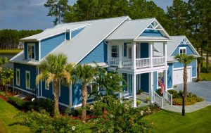 Blue Coastal Home With White Trim and Metal Roof