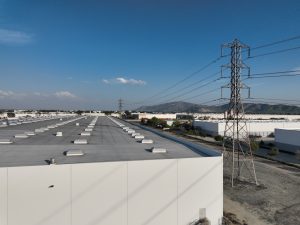 Industrial Warehouses and Power Lines Under Blue Sky