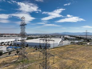 Power Lines Over Industrial Warehouse and Mountains