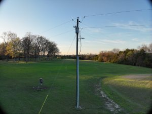 Serene Grassy Field With Utility Pole at Sunset