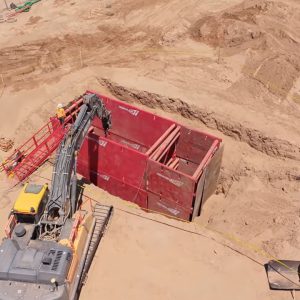 Hudson construction site with excavator, red storage container, and earthwork in progress.
