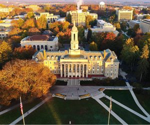 Aerial imagery of historic university campus with autumn foliage and clock tower.