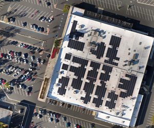 Aerial view of retail warehouse solar panels and parking lot.