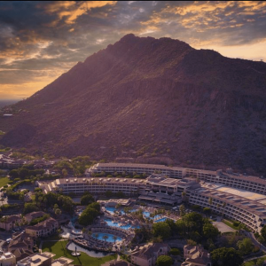 Luxury mountain resort with sunset pool, palm trees, and scenic desert landscape.